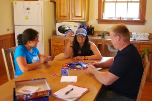 Three friends playing a card game together at a table